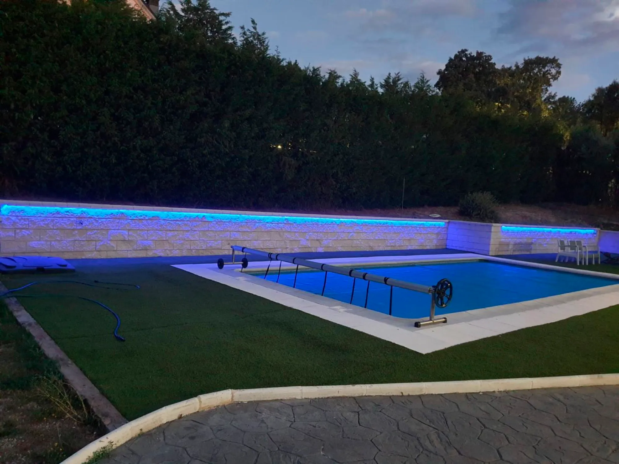 Piscina y exterior reformados al anochecer